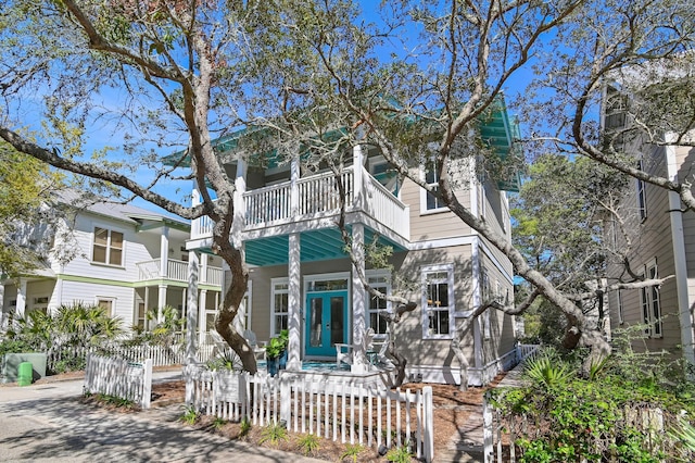 68 N Ryan St, Santa Rosa Beach, FL 32459 - view of front facade featuring a balcony, a fenced front yard, and french doors