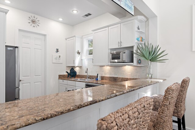 68 N Ryan St, Santa Rosa Beach, FL 32459 - kitchen featuring freestanding refrigerator, tasteful backsplash, dark stone counters, and visible vents