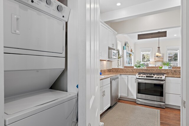 68 N Ryan St, Santa Rosa Beach, FL 32459 - kitchen with wood finished floors, stacked washing maching and dryer, stainless steel appliances, white cabinets, and recessed lighting