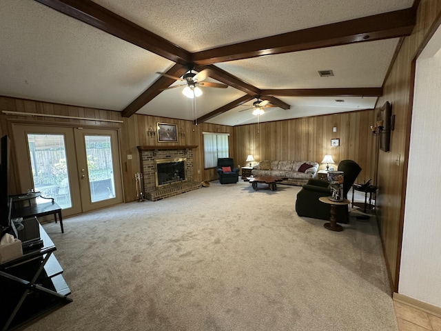 living room with wood walls, a textured ceiling, visible vents, and carpet