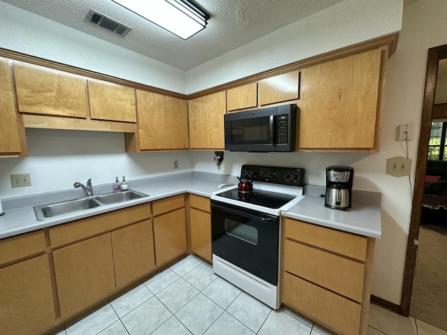 kitchen featuring a sink, black microwave, visible vents, light countertops, and electric range