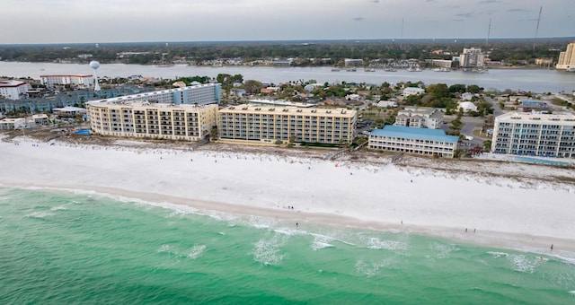 drone / aerial view featuring a water view, a view of the beach, and a city view