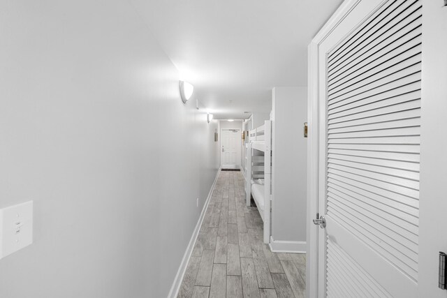 hallway with baseboards and wood finish floors