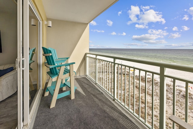 balcony featuring a beach view and a water view
