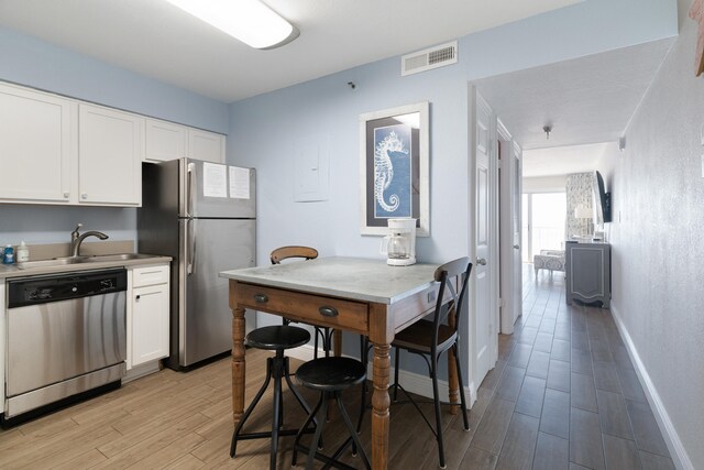 790 Santa Rosa Blvd Unit 403, Fort Walton Beach, FL 32548 - kitchen featuring white cabinets, visible vents, stainless steel appliances, a sink, and light wood-type flooring