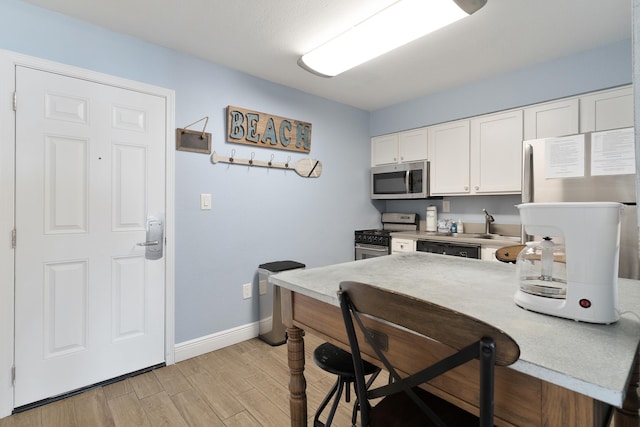 790 Santa Rosa Blvd Unit 403, Fort Walton Beach, FL 32548 - kitchen with a kitchen bar, light countertops, light wood-type flooring, stainless steel appliances, and white cabinets