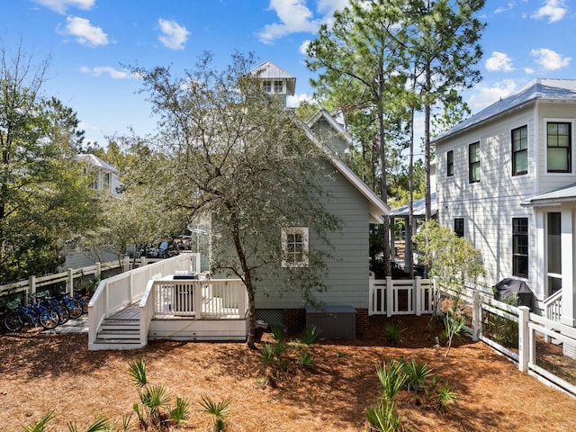 view of property exterior featuring a wooden deck and fence