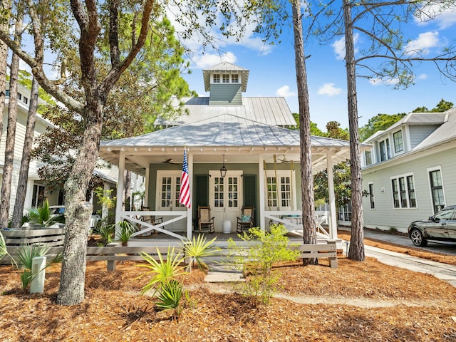 rear view of property with a porch and metal roof