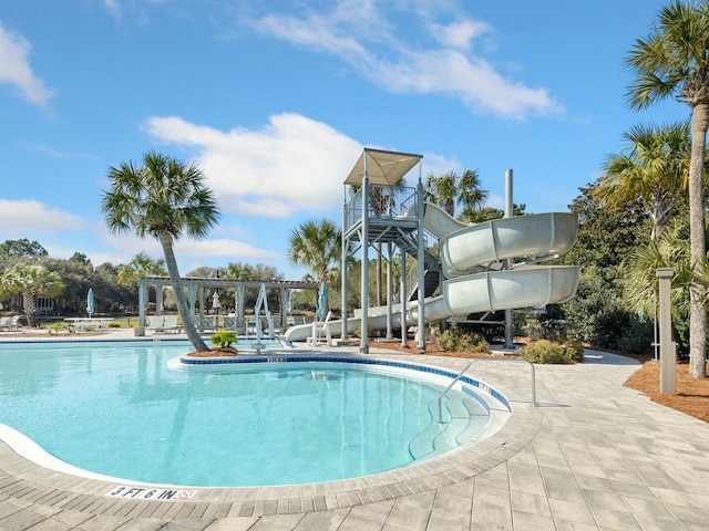 community pool with a patio, a pergola, and a water slide