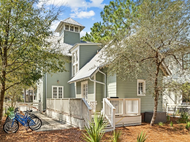 rear view of property featuring a patio and a deck