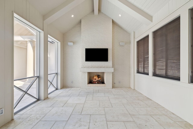 342 Windsong Dr, Inlet Beach, FL 32461 - unfurnished living room with lofted ceiling with beams, a lit fireplace, recessed lighting, and stone tile flooring