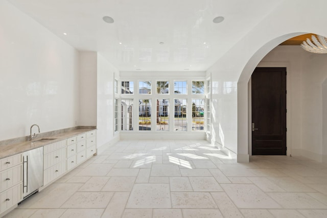 342 Windsong Dr, Inlet Beach, FL 32461 - interior space featuring baseboards, recessed lighting, arched walkways, a sink, and stone tile floors