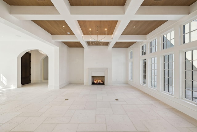 342 Windsong Dr, Inlet Beach, FL 32461 - unfurnished living room featuring coffered ceiling, wooden ceiling, a lit fireplace, baseboards, and arched walkways