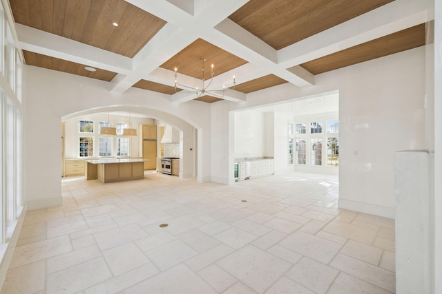 342 Windsong Dr, Inlet Beach, FL 32461 - unfurnished living room with coffered ceiling, a wealth of natural light, arched walkways, and wood ceiling