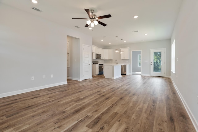 6119 Tansey St, Crestview, FL 32539 - unfurnished living room featuring a ceiling fan, wood finished floors, baseboards, recessed lighting, and a sink