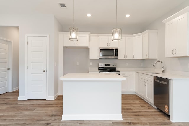 6119 Tansey St, Crestview, FL 32539 - kitchen with appliances with stainless steel finishes, a sink, white cabinets, light wood-style floors, and recessed lighting
