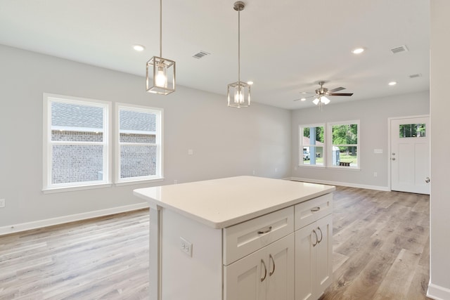 6119 Tansey St, Crestview, FL 32539 - kitchen featuring light wood finished floors, open floor plan, white cabinets, pendant lighting, and a center island