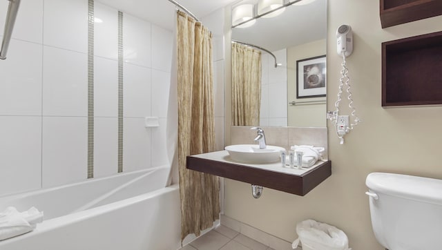 full bath with tile patterned floors, a sink, toilet, and shower / tub combo