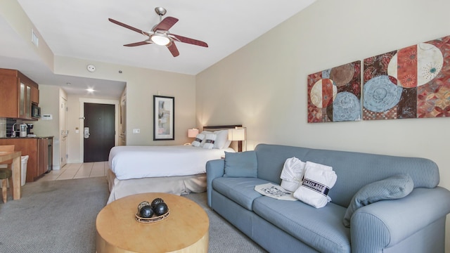 bedroom featuring light carpet, light tile patterned flooring, and a ceiling fan