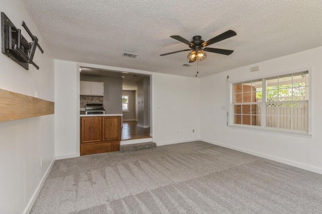 217 NW Martisa Rd, Fort Walton Beach, FL 32548 - unfurnished living room with a textured ceiling, ceiling fan, carpet flooring, and baseboards