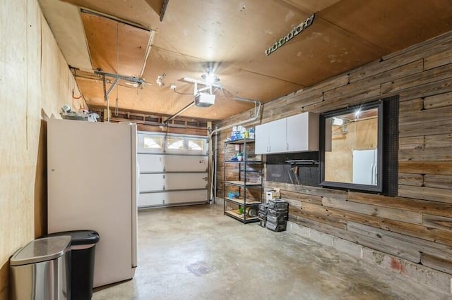 217 NW Martisa Rd, Fort Walton Beach, FL 32548 - garage featuring wood walls, freestanding refrigerator, and a garage door opener