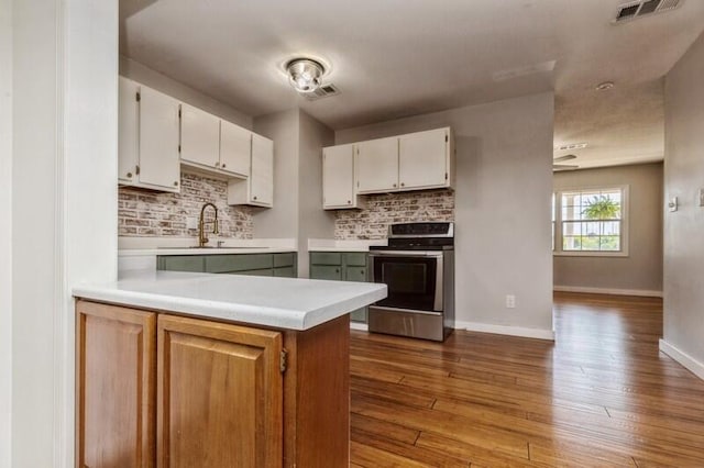 217 NW Martisa Rd, Fort Walton Beach, FL 32548 - kitchen featuring electric range, a sink, light countertops, tasteful backsplash, and white cabinets