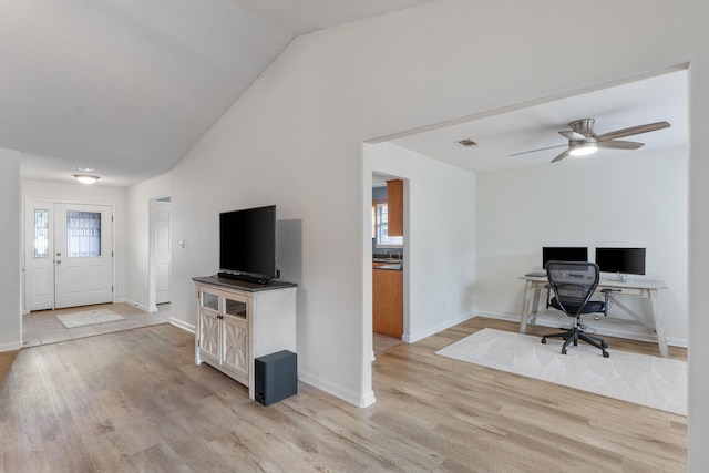 interior space with visible vents, vaulted ceiling, ceiling fan, baseboards, and light wood-type flooring