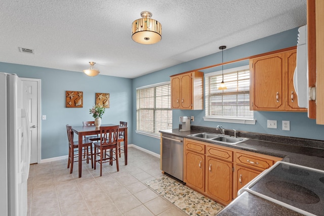 kitchen featuring a sink, visible vents, dark countertops, dishwasher, and freestanding refrigerator