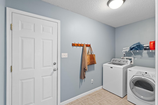 laundry area featuring separate washer and dryer, baseboards, laundry area, and a textured ceiling