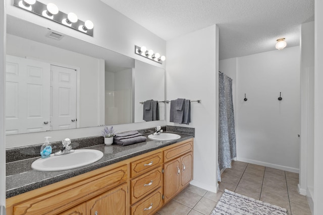 bathroom with double vanity, a sink, tile patterned floors, and visible vents