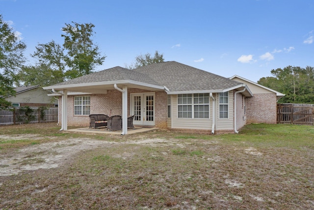 back of property featuring a patio area, a fenced backyard, a lawn, brick siding, and french doors