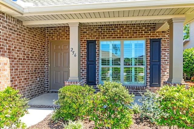 256 Cocobolo Dr, Santa Rosa Beach, FL 32459 - view of exterior entry featuring brick siding and covered porch