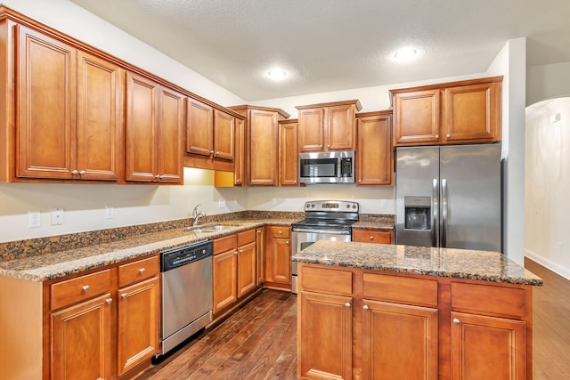 256 Cocobolo Dr, Santa Rosa Beach, FL 32459 - kitchen featuring stainless steel appliances, a sink, brown cabinets, and dark wood finished floors