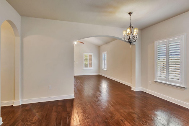 256 Cocobolo Dr, Santa Rosa Beach, FL 32459 - unfurnished room with arched walkways, a chandelier, baseboards, and dark wood-style floors