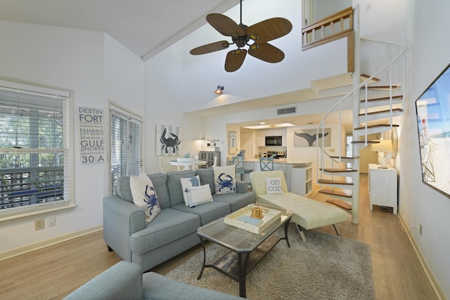 9815 W US Highway 98 Unit 215, Miramar Beach, FL 32550 - living area featuring stairway, a high ceiling, a ceiling fan, visible vents, and wood finished floors