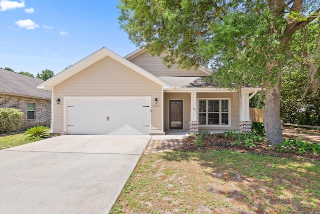 8393 New Orleans Ct, Navarre, FL 32566 - view of front facade featuring a garage, driveway, brick siding, and a porch