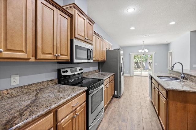 8393 New Orleans Ct, Navarre, FL 32566 - kitchen with appliances with stainless steel finishes, a sink, a chandelier, light wood-type flooring, and recessed lighting