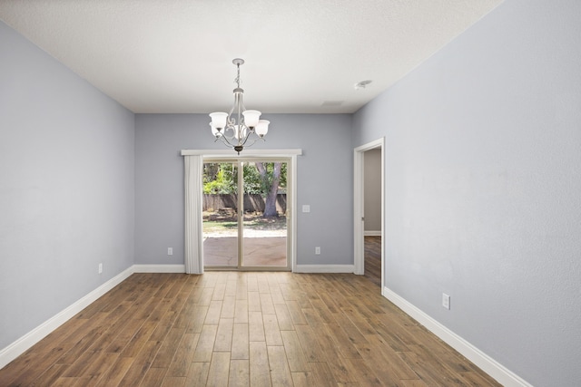 8393 New Orleans Ct, Navarre, FL 32566 - empty room with a chandelier, wood finished floors, and baseboards