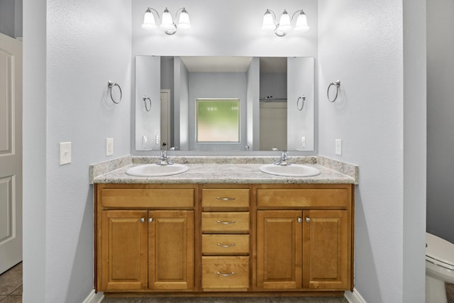8393 New Orleans Ct, Navarre, FL 32566 - bathroom with double vanity, toilet, tile patterned flooring, and baseboards