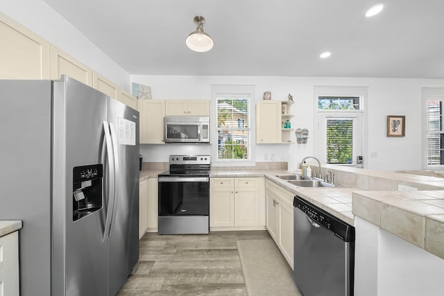 198 Somerset Bridge Rd Unit 117, Santa Rosa Beach, FL 32459 - kitchen featuring recessed lighting, light wood-type flooring, stainless steel appliances, a sink, and tile countertops