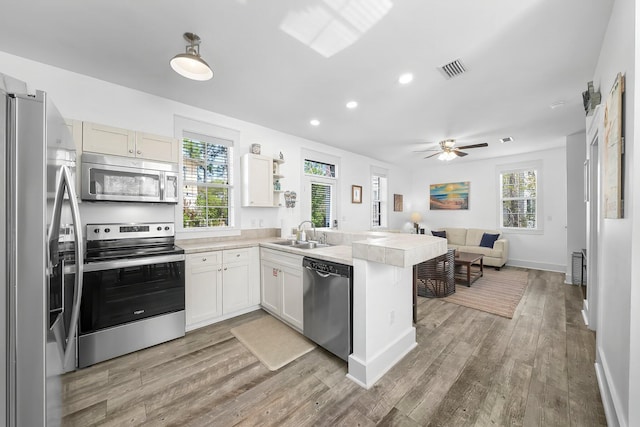 198 Somerset Bridge Rd Unit 117, Santa Rosa Beach, FL 32459 - kitchen featuring open floor plan, a sink, light wood finished floors, a peninsula, and appliances with stainless steel finishes