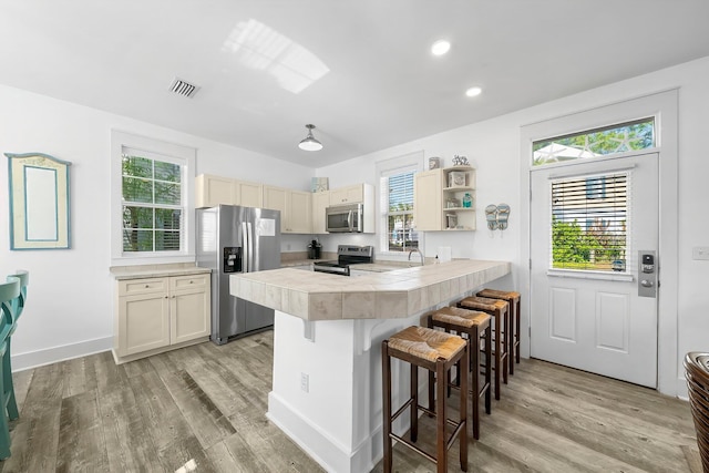 198 Somerset Bridge Rd Unit 117, Santa Rosa Beach, FL 32459 - kitchen featuring light countertops, a kitchen bar, a peninsula, light wood-type flooring, and stainless steel appliances
