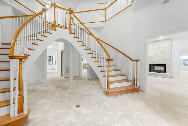 680 Mallet Bayou Rd, Freeport, FL 32439 - stairs with concrete flooring, a high ceiling, a fireplace, and visible vents
