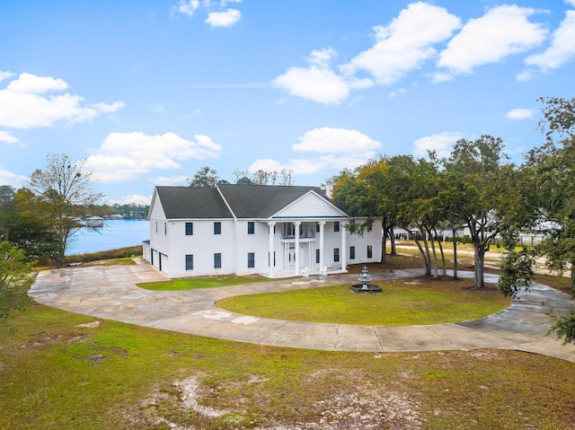 680 Mallet Bayou Rd, Freeport, FL 32439 - back of property with curved driveway, stucco siding, an attached garage, a water view, and a yard