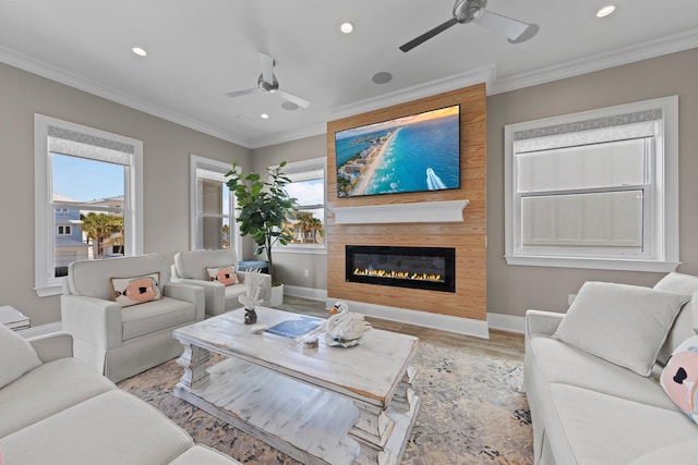 living area with plenty of natural light, ornamental molding, and a ceiling fan