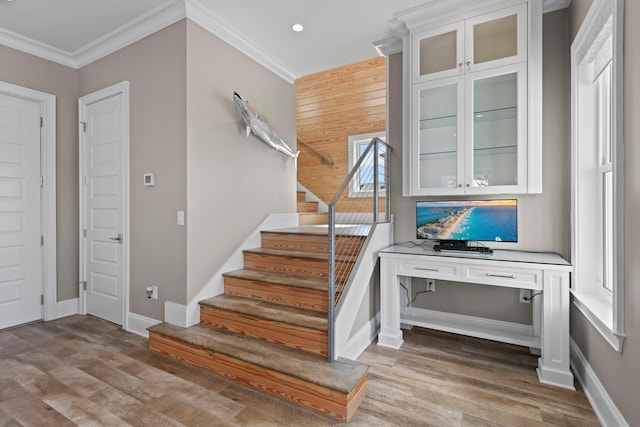 stairs featuring baseboards, wood finished floors, and ornamental molding