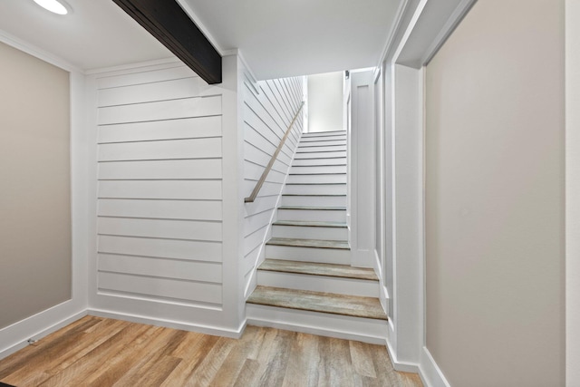 staircase featuring baseboards and wood finished floors