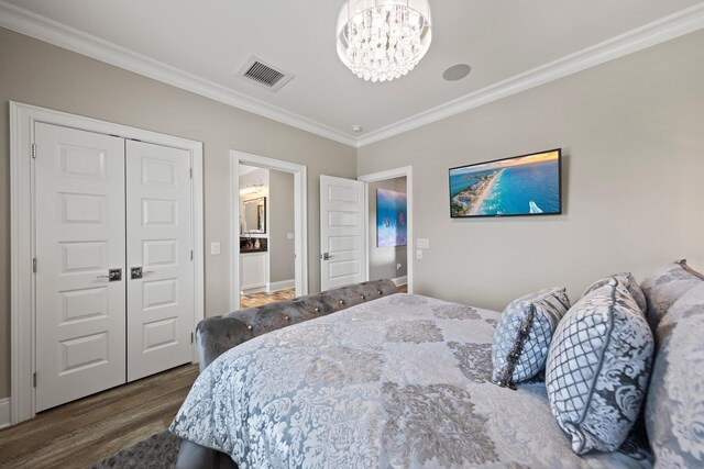 bedroom with visible vents, crown molding, wood finished floors, and an inviting chandelier