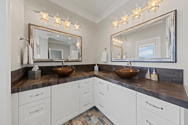 full bath with double vanity, a sink, and crown molding