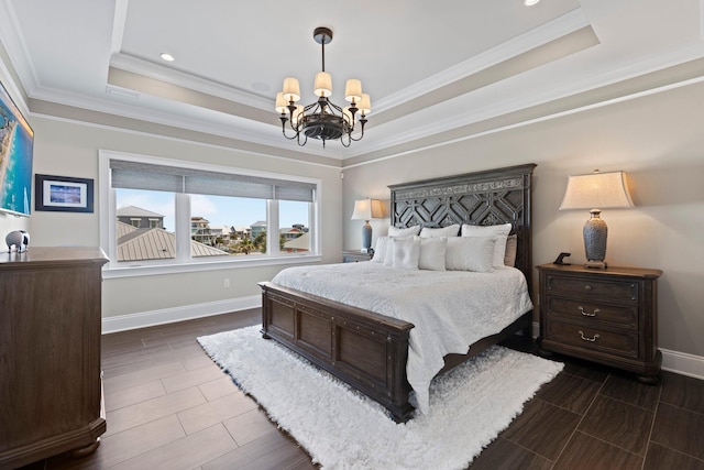 bedroom featuring an inviting chandelier, ornamental molding, a tray ceiling, and baseboards